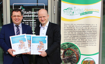 LENA-​Geschäftsführer Marko Mühlstein übergibt Bauherrenmappen an Stadtwerke-​Geschäftsführer Tim Schlenkermann